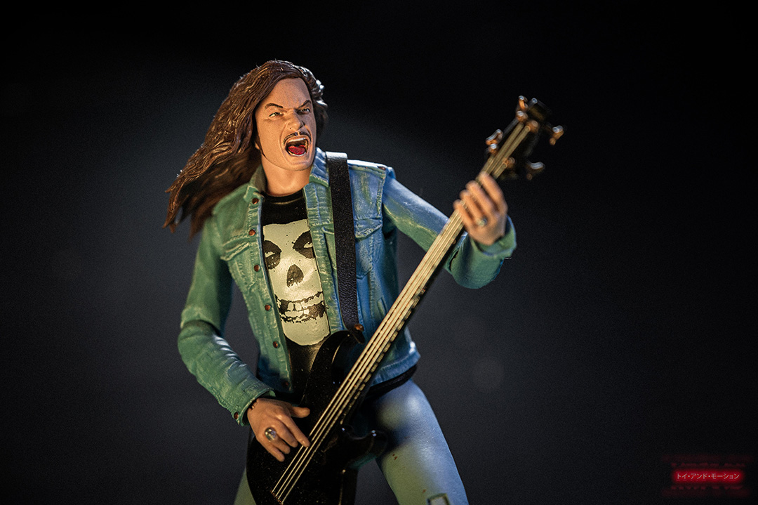 Figurine Cliff Burton Super7 Ultimates posant avec sa basse, hommage au légendaire bassiste de Metallica. (Keywords: Cliff Burton figurine, Metallica, Super7, toy photography, collectionneur)